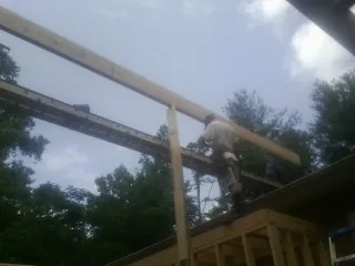 Carpenter setting a ridge beam over a new addition frame — Ice Dam Removal by Roofing Brothers in Jackson Center