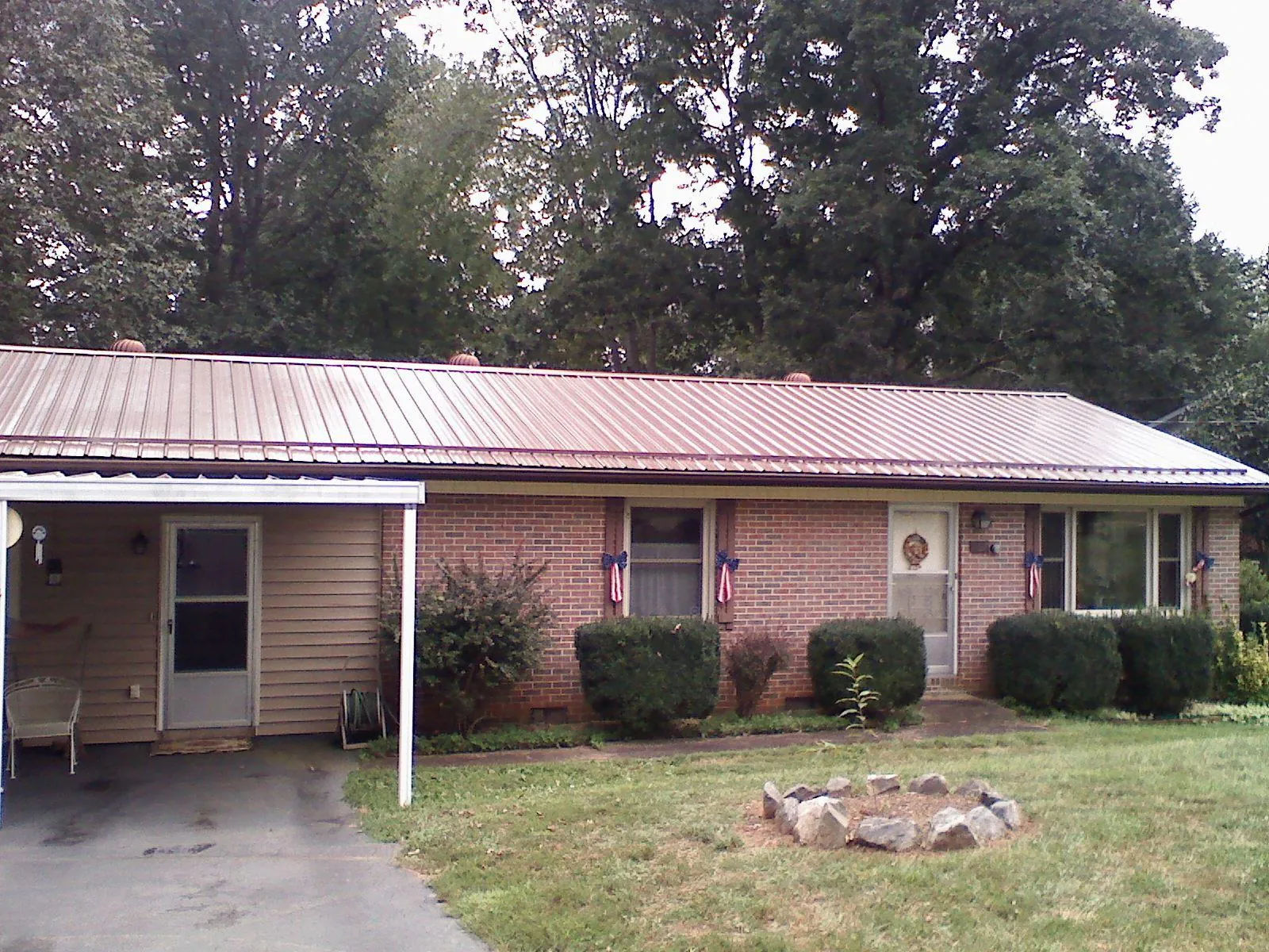 Bronze metal roof and carport on a brick ranch home — Roof Repair work by our crew in Jackson Center